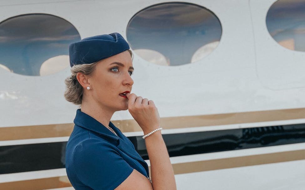 air stewardess standing by airplane
