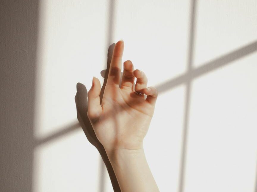 female hand against wall with shadow