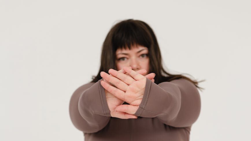 overweight woman showing stop gesture in studio