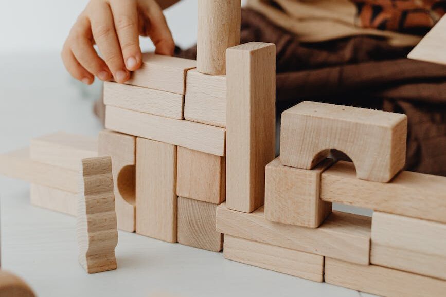 selective focus photo of a kid stacking building blocks