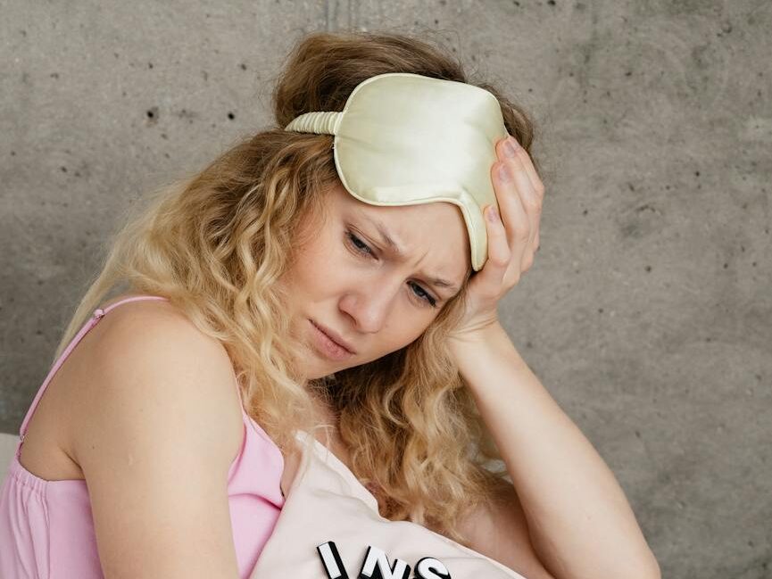 woman in pink tank top holding a pillow