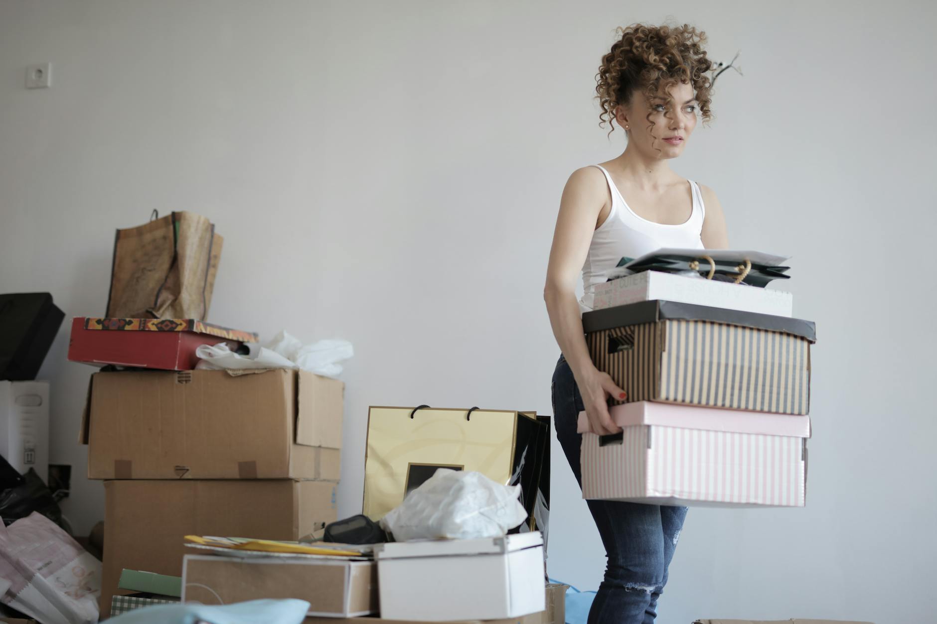断捨離
concentrated woman carrying stack of cardboard boxes for relocation