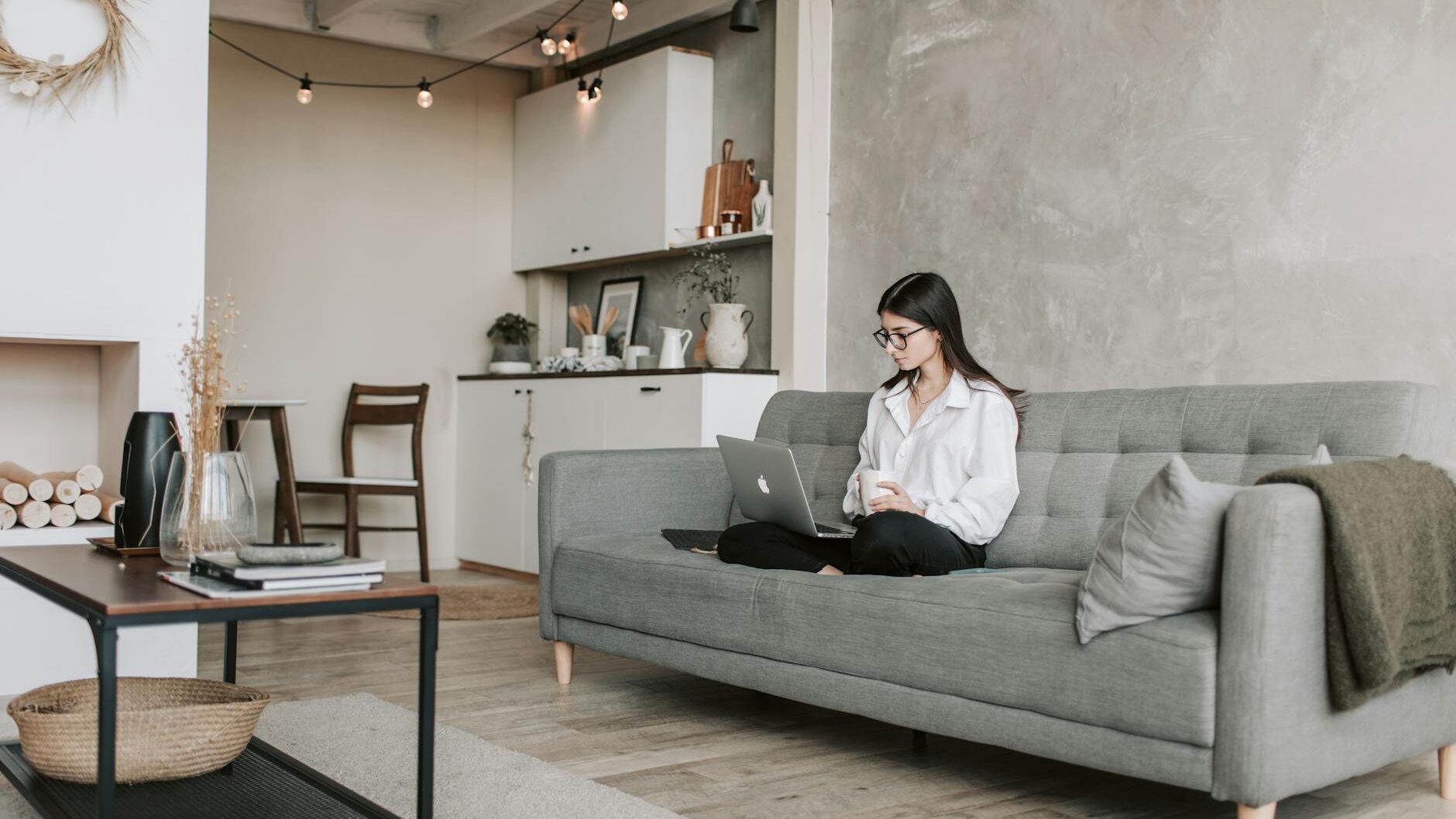 reason minimalist
woman sitting on a sofa while working with laptop